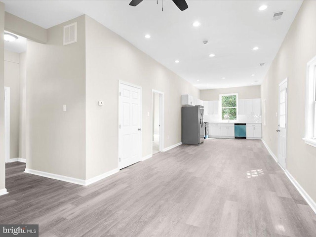 unfurnished living room with ceiling fan and light hardwood / wood-style flooring