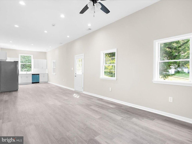 unfurnished living room featuring light hardwood / wood-style floors, ceiling fan, and a healthy amount of sunlight