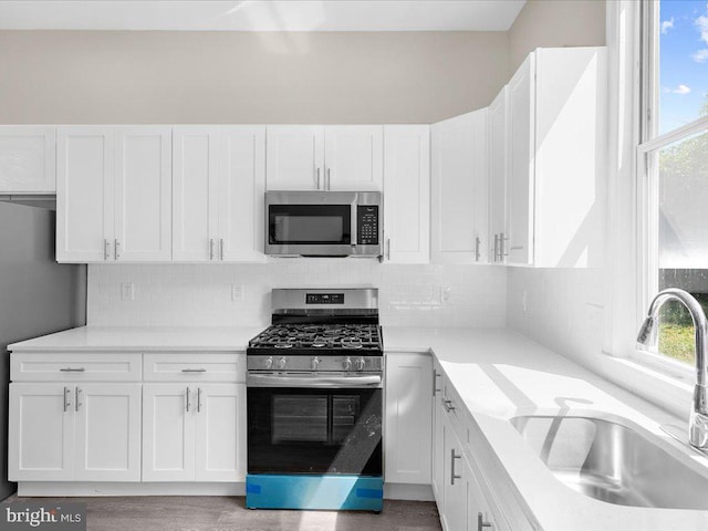 kitchen with white cabinets, appliances with stainless steel finishes, and sink