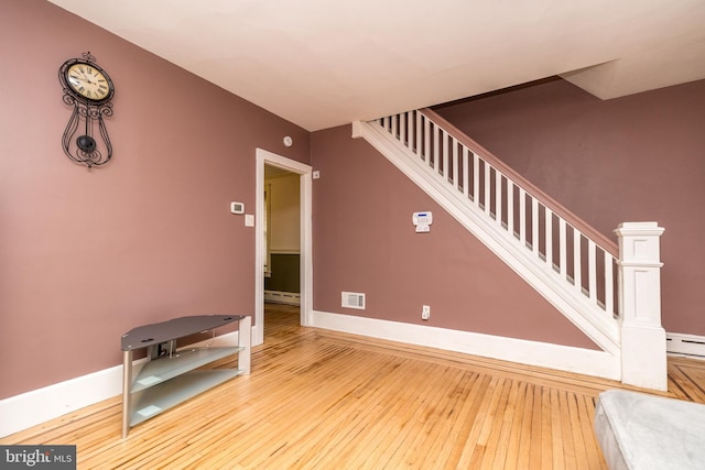 interior space with wood-type flooring and baseboard heating