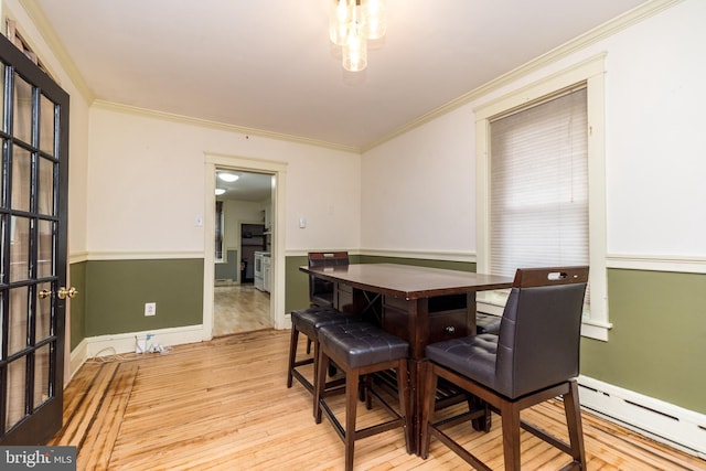 dining space featuring crown molding, light hardwood / wood-style flooring, and a baseboard radiator