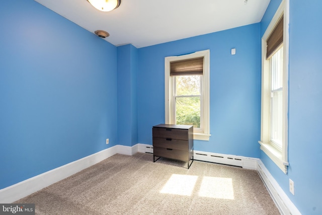 spare room featuring light colored carpet and baseboard heating