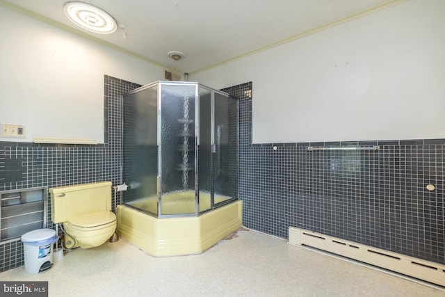 bathroom with tile walls, a baseboard heating unit, an enclosed shower, and toilet