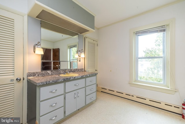 bathroom with ornamental molding, vanity, and a baseboard heating unit