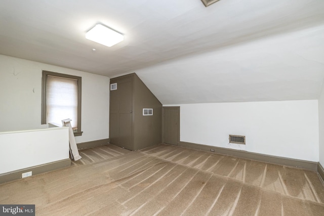 bonus room with vaulted ceiling and carpet floors