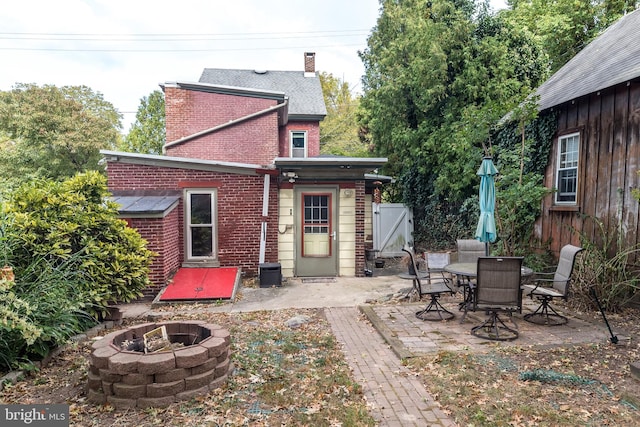 rear view of house with a fire pit and a patio area