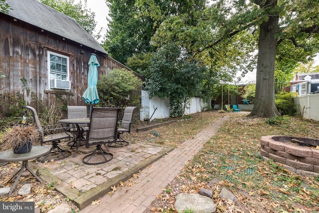 view of yard featuring cooling unit, a patio, and an outdoor fire pit