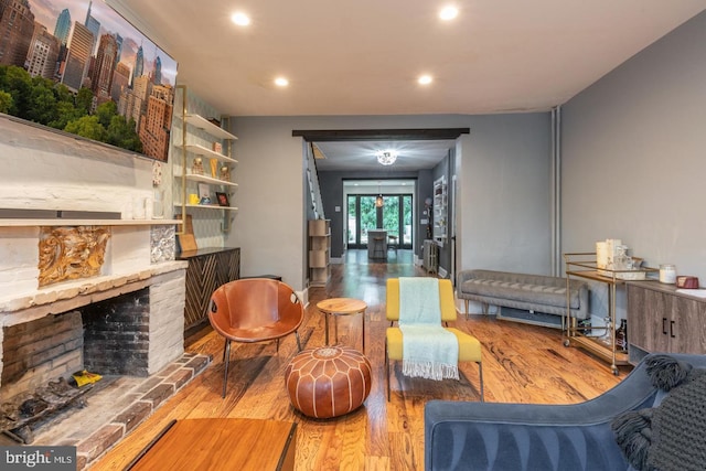 living room featuring a stone fireplace and hardwood / wood-style flooring