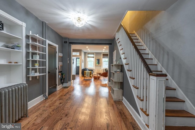 entrance foyer with hardwood / wood-style floors and radiator heating unit