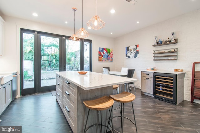 kitchen featuring pendant lighting, beverage cooler, white cabinetry, a kitchen island, and a kitchen breakfast bar