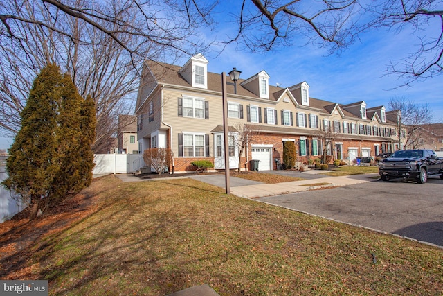 view of property featuring a garage and a front yard