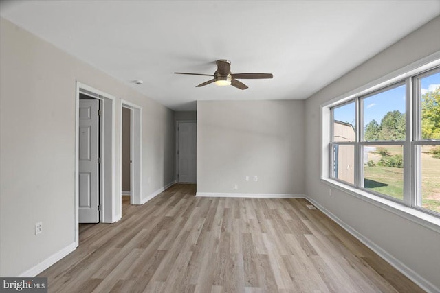 interior space featuring light hardwood / wood-style flooring, multiple windows, and ceiling fan