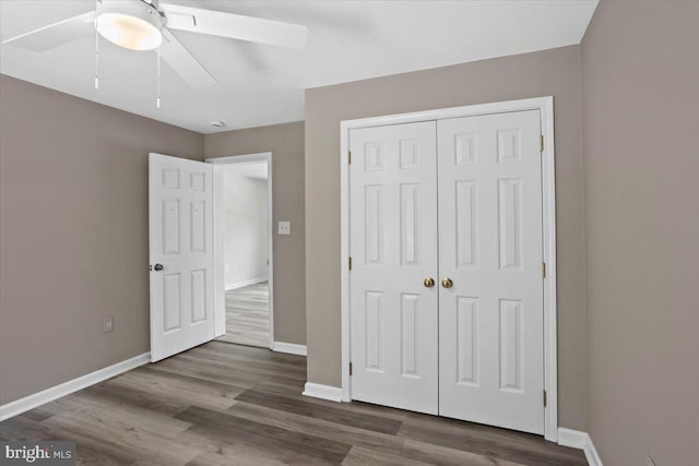 unfurnished bedroom with ceiling fan, a closet, and dark hardwood / wood-style floors