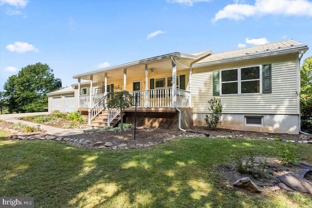 back of property with covered porch and a yard