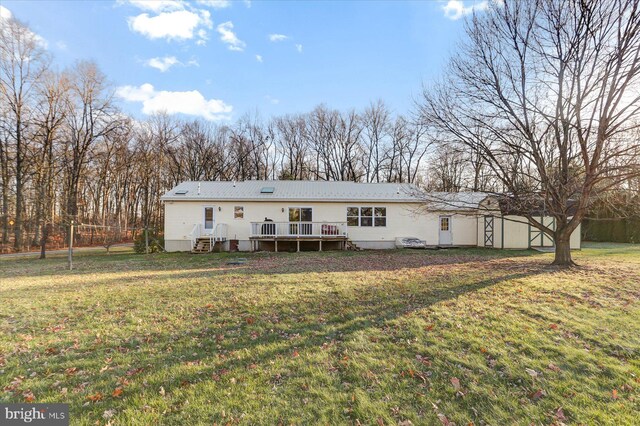 back of property with a deck and a lawn