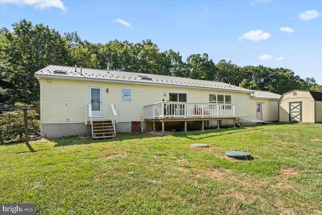 rear view of property featuring a shed, a yard, and a wooden deck