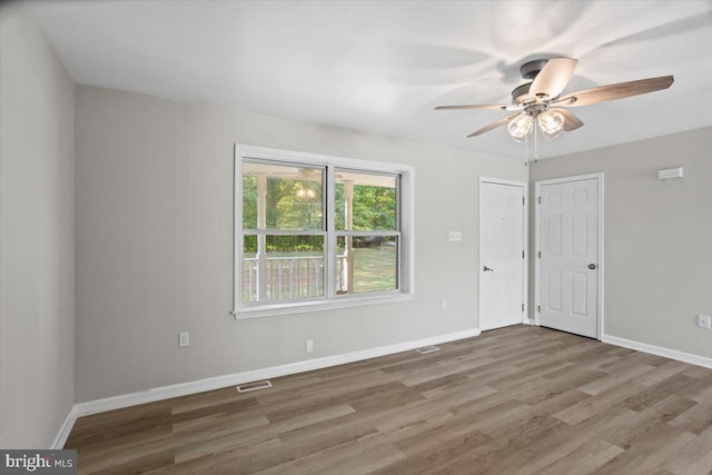 empty room with ceiling fan and hardwood / wood-style flooring