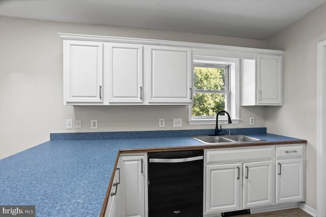 kitchen with stainless steel dishwasher, white cabinetry, and sink