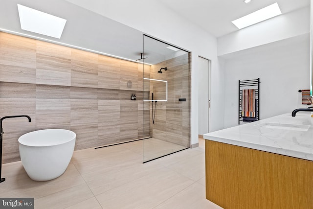 bathroom with vanity, a skylight, tile patterned floors, and independent shower and bath