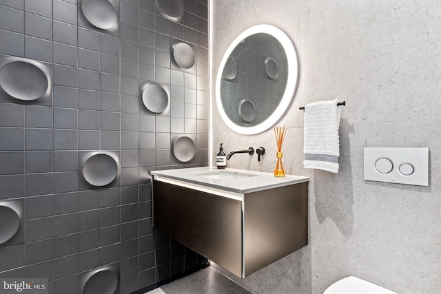 bathroom with vanity and tile walls