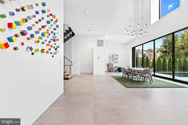 interior space featuring a towering ceiling and a chandelier