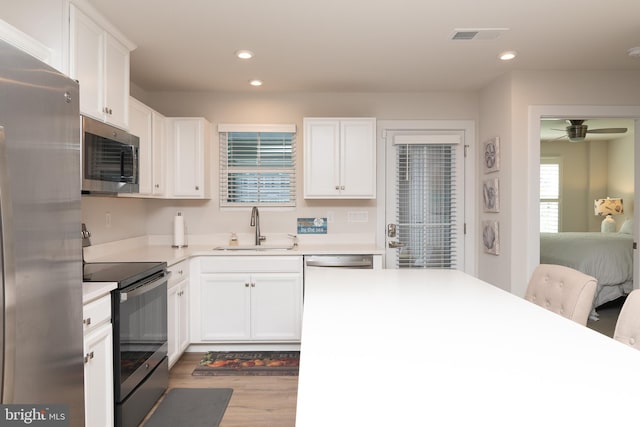 kitchen featuring white cabinets, hardwood / wood-style flooring, stainless steel appliances, and sink