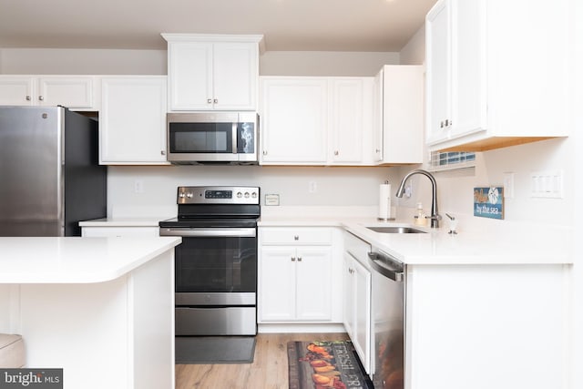 kitchen featuring appliances with stainless steel finishes, sink, and white cabinets