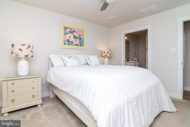 bedroom featuring light carpet, ceiling fan, and connected bathroom