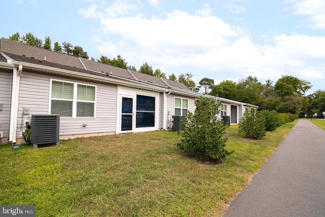 view of side of home featuring a yard and cooling unit