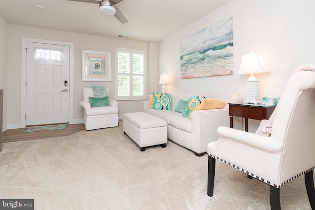 living room with light hardwood / wood-style flooring and ceiling fan