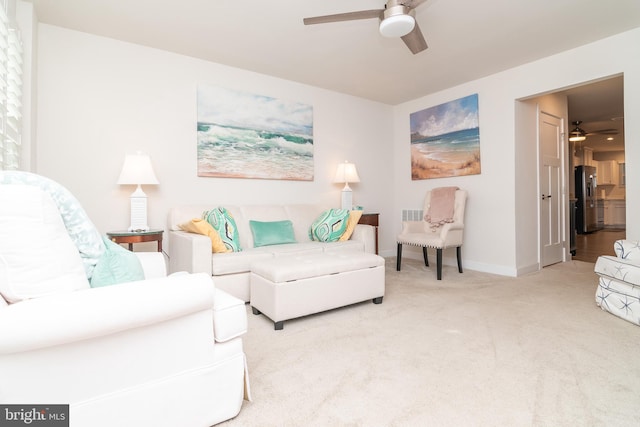 carpeted living room with ceiling fan