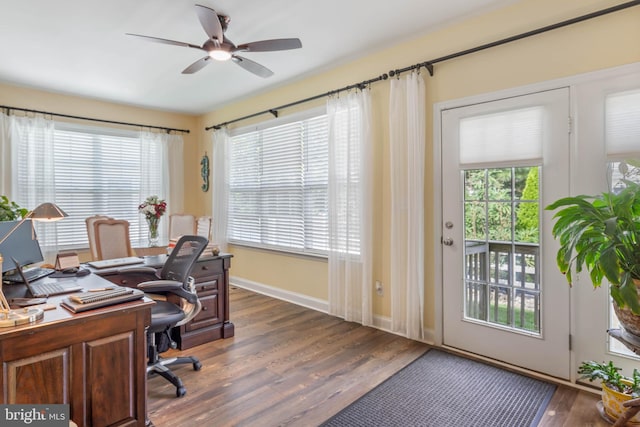 home office featuring ceiling fan, a healthy amount of sunlight, and dark hardwood / wood-style floors