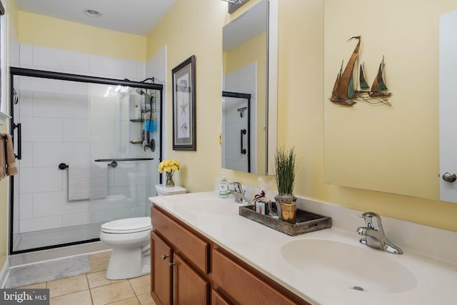 bathroom with tile patterned flooring, vanity, toilet, and an enclosed shower