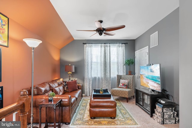 carpeted living room with ceiling fan and lofted ceiling