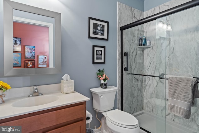 bathroom featuring vanity, toilet, and a shower with door