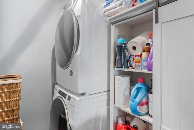 laundry area featuring a barn door and stacked washer and dryer