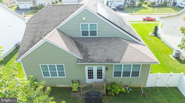 rear view of property featuring central air condition unit and a yard