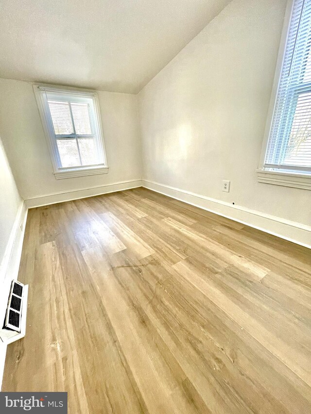 interior space with light wood-type flooring and vaulted ceiling