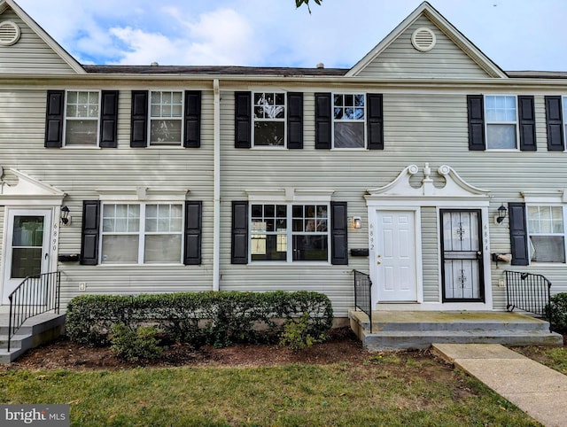 townhome / multi-family property featuring a front lawn