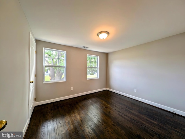 spare room with dark hardwood / wood-style floors