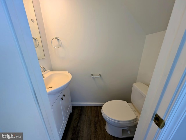 bathroom featuring wood-type flooring, vanity, and toilet