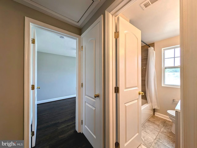 corridor with baseboards and visible vents