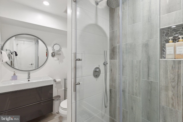 bathroom with vanity, toilet, and a shower with shower door