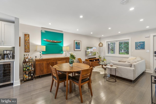 dining space with beverage cooler and hardwood / wood-style flooring