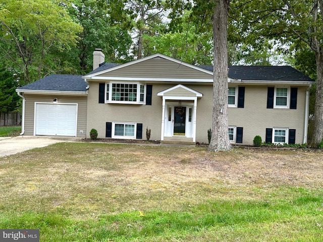 split foyer home with a garage and a front lawn