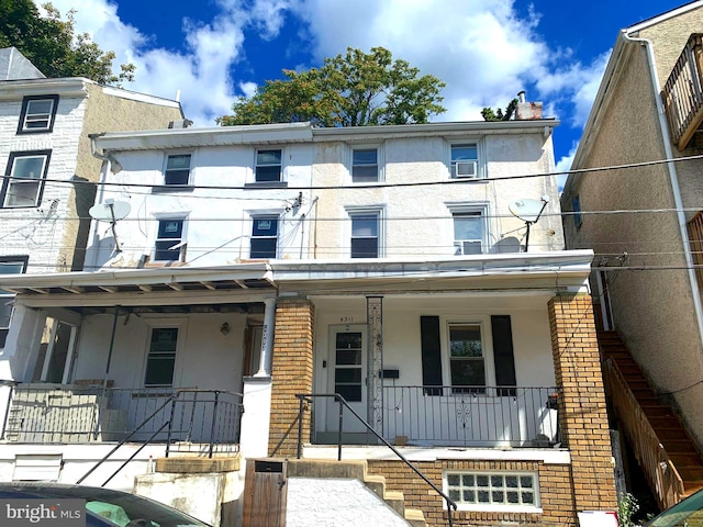 townhome / multi-family property featuring covered porch