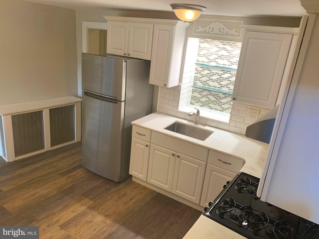 kitchen featuring dark hardwood / wood-style floors, stainless steel fridge, backsplash, and sink