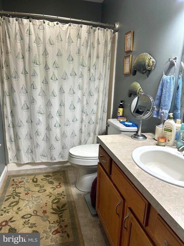 full bathroom with shower / tub combo, toilet, tile patterned flooring, and vanity