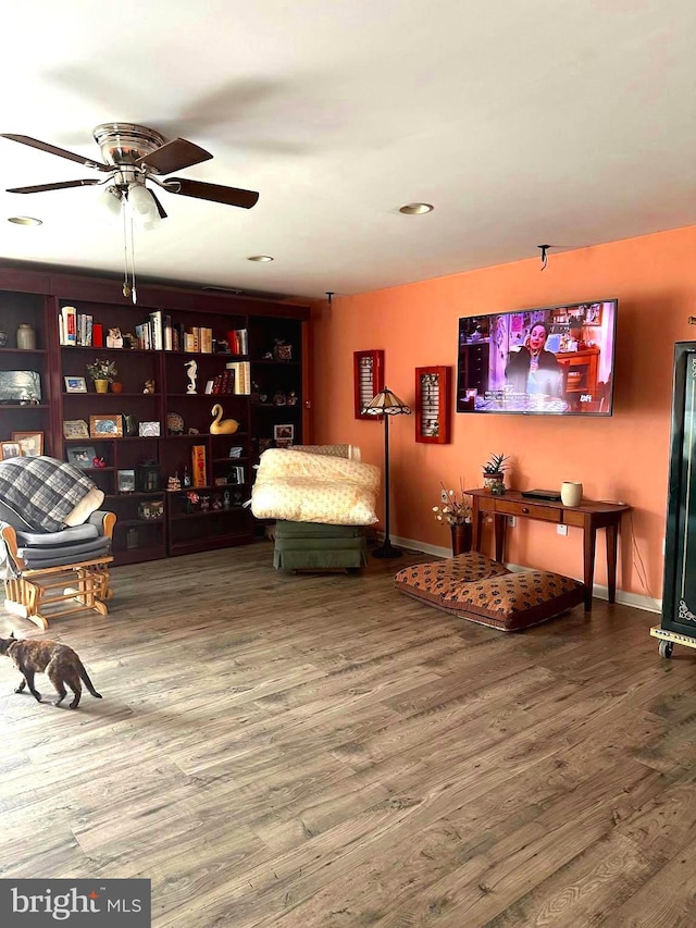 sitting room with wood-type flooring and ceiling fan