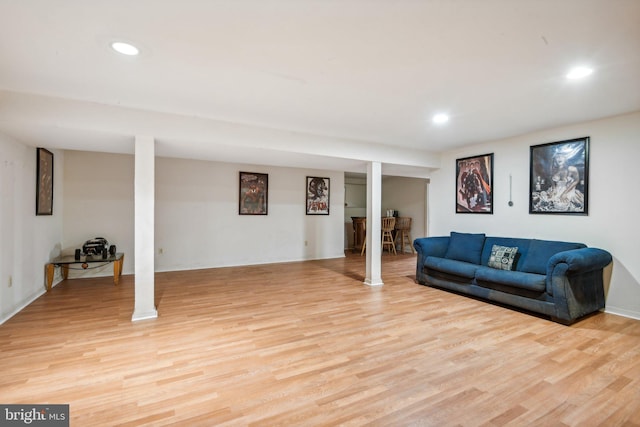 living room featuring light hardwood / wood-style floors and ornate columns